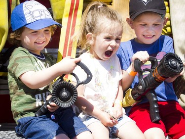 Chums l-r two and a half year old Jack Doyle, two and a half-year-old Mia Mastromatteo and five-year-old Luca Mastromatteo on the back of a fire truck at the Touch A Truck event at Lincoln Fields Shopping Centre Sunday June 10, 2018.