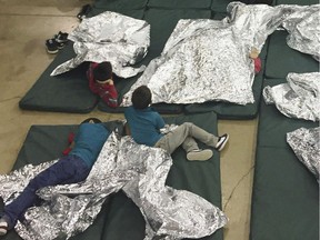 In this photo provided by U.S. Customs and Border Protection, people who've been taken into custody related to cases of illegal entry into the United States, rest in one of the cages at a facility in McAllen, Texas, Sunday, June 17, 2018.