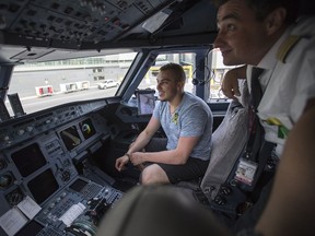 Humboldt Broncos bus crash survivor Kaleb Dahlgren, left, is shown the flight deck of an airplane by Air Canada pilot Mathieu Dussault during their layover in Calgary, before heading to Las Vegas for the NHL awards, in Calgary, AB on Monday, June 18, 2018.