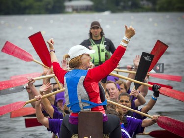 Sue Holloway, a four-time Olympian in kayak and cross-country skiing, cheers at the front of the boat after her team crossed the finish line.