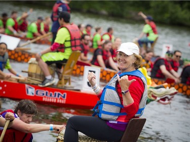 Sue Holloway, a four-time Olympian in kayak and cross-country skiing, cheers at the front of the boat after her team crossed the finish line.