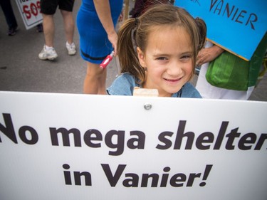 Residents opposed to the Salvation Army's plans for a new shelter and facility in Vanier took their message to the streets, marching through their community Sunday June 24, 2018. Six-year-old Hazel Bartlett holds a sign saying no mega shelters in Vanier!