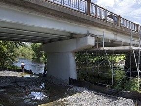 OTTAWA June 20, 2013 -- Workers on their lunch break try some fishing under the Jockvale Bridge.  Reports of the barn swallows nesting under the bridge have apparently shut down construction until August, the end of nesting season. (Wayne Cuddington / Ottawa Citizen) 113505