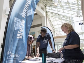 City of Ottawa election specialists' Christine Hanson (R) and Lionel Minkutu assist Sabah Haibeh (L) with her paperwork necessary to work during the municipal election. June 26, 2018.