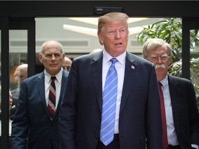 U.S. President Donald Trump leaves with Chief of Staff John Kelly (L) and National Security Adviser John Bolton (R) after holding a press conference ahead of his departure from the G7 Summit on June 9 in La Malbaie, Que.