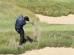 Patrick Reed plays his second shot from a bunker on the 14th hole during the third round of the U.S. Open on Saturday.