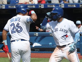 Teoscar Hernandez #37 of the Toronto Blue Jays is congratulated by Yangervis Solarte #26 after hitting a solo home run in the eighth inning during MLB game action against the Washington Nationals at Rogers Centre on June 17, 2018 in Toronto.