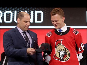 Brady Tkachuk accepts a Senators hat from the team's chief amateur scout, Trent Mann, after being selected fourth overall in Dallas on Friday evening.