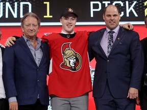 Jacob Bernard-Docker with Senators owner Eugene Melnyk, left, and chief scout Trent Mann, right, on Friday night in Dallas.