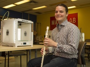 University of Ottawa PhD student Rob Hunter with the first iteration of his 3D-printed clarinet and brace. On the table beside him is a 3D printer. Hunter is one of three finalists in the Ottawa Symphony Orchestra's National 3D Printed Musical Instrument Challenge.