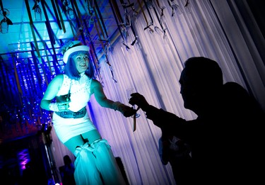 Stilt performer Andrée Rainville hands a champagne flute that was hanging by a ribbon from the ceiling to a guest.