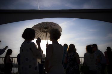 Lara van Loon, a gala committee member, uses a parasol as the warm summer sun starts to set.