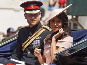 Britain's Prince Harry, Duke of Sussex and Britain's Meghan, Duchess of Sussex return in a horse-drawn carriage after attending the Queen's Birthday Parade, 'Trooping the Colour' on Horseguards parade in London on June 9, 2018.   The ceremony of Trooping the Colour is believed to have first been performed during the reign of King Charles II. In 1748, it was decided that the parade would be used to mark the official birthday of the Sovereign. More than 600 guardsmen and cavalry make up the parade, a celebration of the Sovereign's official birthday, although the Queen's actual birthday is on 21 April.