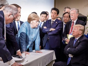 A photo released on Twitter by the German Government's spokesman Steffen Seibert on June 9, 2018 and taken by the German government's photographer Jesco Denzel shows U.S. President Donald Trump (R) talking with German Chancellor Angela Merkel (C) and surrounded by other G7 leaders during a meeting of the G7 Summit in La Malbaie, Quebec, Canada.