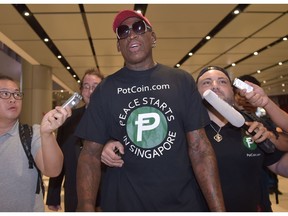 TOPSHOT - Retired American professional basketball player Dennis Rodman speaks to the press as he arrives at Changi International airport ahead of US-North Korea summit in Singapore on June 11, 2018.  North Korea's  Kim Jong Un and US President Donald Trump meet on June 12 for an unprecedented summit in an attempt to address the last festering legacy of the Cold War, with the US President calling it a "one time shot" at peace.