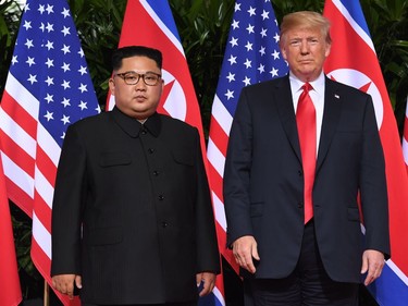 US President Donald Trump (R) and North Korea's leader Kim Jong Un (L) pose together at the start of their historic US-North Korea summit, at the Capella Hotel on Sentosa island in Singapore on June 12, 2018. Donald Trump and Kim Jong Un have become on June 12 the first sitting US and North Korean leaders to meet, shake hands and negotiate to end a decades-old nuclear stand-off.