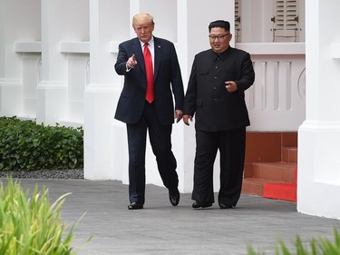 North Korea's leader Kim Jong Un (R) walks with US President Donald Trump (L) during a break in talks at their historic US-North Korea summit, at the Capella Hotel on Sentosa island in Singapore on June 12, 2018. Donald Trump and Kim Jong Un became on June 12 the first sitting US and North Korean leaders to meet, shake hands and negotiate to end a decades-old nuclear stand-off.