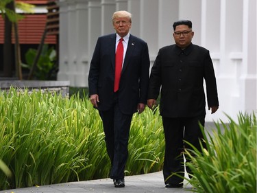 TOPSHOT - North Korea's leader Kim Jong Un (R) walks with US President Donald Trump (L) during a break in talks at their historic US-North Korea summit, at the Capella Hotel on Sentosa island in Singapore on June 12, 2018.  Donald Trump and Kim Jong Un became on June 12 the first sitting US and North Korean leaders to meet, shake hands and negotiate to end a decades-old nuclear stand-off.