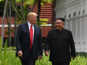 North Korea's leader Kim Jong Un (R) walks with US President Donald Trump (L) during a break in talks at their historic US-North Korea summit, at the Capella Hotel on Sentosa island in Singapore on June 12, 2018.