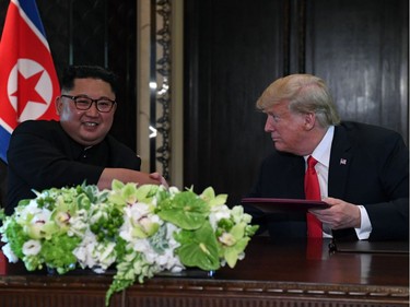 TOPSHOT - North Korea's leader Kim Jong Un (L) shakes hands with US President Donald Trump at a signing ceremony during their historic US-North Korea summit, at the Capella Hotel on Sentosa island in Singapore on June 12, 2018.  Donald Trump and Kim Jong Un became on June 12 the first sitting US and North Korean leaders to meet, shake hands and negotiate to end a decades-old nuclear stand-off.