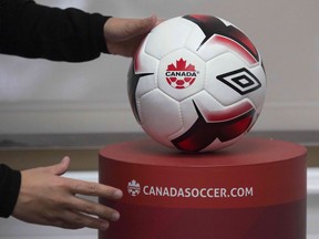 An employee adjusts a soccer ball at Soccer Canada Headquarters in Ottawa, Ontario on June 13, 2018, as Canada will co-host the 2026 World Cup with Mexico and the US. The 2026 World Cup hosted by Canada, Mexico and the United States will be "a great tournament," Canadian Prime Minister Justin Trudeau said Wednesday.