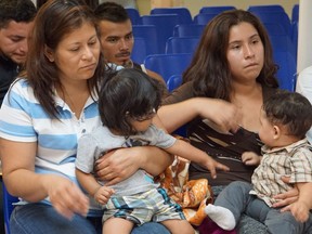 (FILES) In this file photo taken on June 15, 2018 Mothers and children wait to be assisted by volunteers in a humanitarian center in the border town of McAllen, Texas. The UN rights chief on June 18, 2018 condemned the "unconscionable" separation of migrant children from their parents at the US border, as First Lady Melania Trump made a rare political plea to end the deeply controversial practice. The "zero-tolerance" border security policy implemented by President Donald Trump's administration has sparked tears among migrant families and outrage on both sides of the political aisle.It took on particular resonance as America celebrated Father's Day.