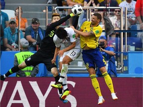 South Korean goalkeeper Cho Hyun-woo, left, punches the ball away from Swedish attackers during Monday's match in Nizhny Novgorod.