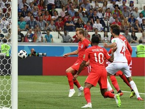 England's Harry Kane, left, scores against Tunisia during the Russia 2018 World Cup Group G football match at Volgograd on Monday.