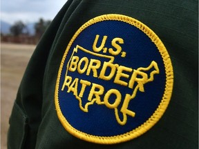 (FILES) In this file photo taken on November 1, 2017 US Border Patrol officer Tekae Michael stands near prototypes of US President Donald Trump's proposed border wall in San Diego, California.  A border patrol agent whose mysterious death prompted President Donald Trump to renew his call for a wall along the US-Mexico border appears to have died as the result of an accident, according to an FBI probe. An FBI investigation into the November 2017 death of agent Rogelio Martinez has not found any evidence of foul play."To date none of the more than 650 interviews completed, locations searched, or evidence collected and analyzed have produced evidence that would support the existence of a scuffle, altercation, or attack," the FBI said in a statement on February 7, 2018.