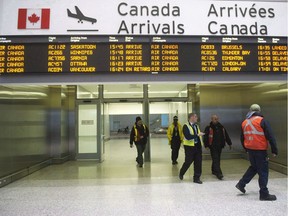 Air Canada workers walk at Pearson International Airport in Toronto on March. 8, 2012.