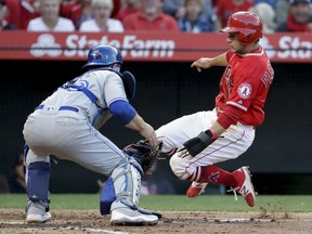 Los Angeles Angels' David Fletcher is tagged out at home by Toronto Blue Jays catcher Russell Martin while trying to score on a fly-out by Luis Valbuena during the third inning of a baseball game in Anaheim, Calif., Saturday, June 23, 2018.