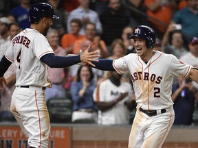 Houston Astros' Alex Bregman (2) celebrates his two-run home run off Toronto Blue Jays relief pitcher Tim Mayza with George Springer during the eighth inning of a baseball game Tuesday, June 26, 2018, in Houston.