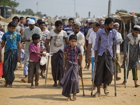 In this April 29, 2018 file photo, wounded Rohingya refugees await the arrival of a U.N. Security Council team at the Kutupalong Rohingya refugee camp in Kutupalong, Bangladesh.