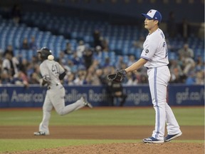 Toronto Blue Jays pitcher Seunghwan Oh takes the ball from his catcher after he gave up a grand slam home run to New York Yankees' Miguel Andujar rounding the bases behind him in the seventh inning of their American League MLB baseball game in Toronto on Tuesday June 5, 2018.