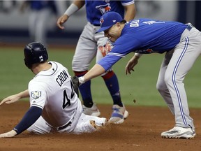 Toronto Blue Jays shortstop Aledmys Diaz, right, tags out Tampa Bay Rays' C.J. Cron on a fielder's choice by Joey Wendle during the sixth inning of a baseball game Wednesday, June 13, 2018, in St. Petersburg, Fla.