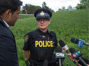 OPP Constable Sue Runciman talks to the media at the scene of the bus crash on the 401 west of Prescott. Photo by Wayne Cuddington/ Postmedia