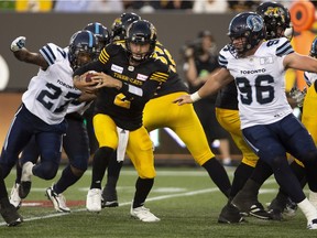 Tiger-Cats quarterback Johnny Manziel (2) scrambles away from Argonauts defensive back Jonathan Dowling (27) during the first half of Friday's game.