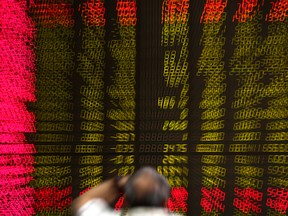 A man watches stock prices at a brokerage house in Beijing.