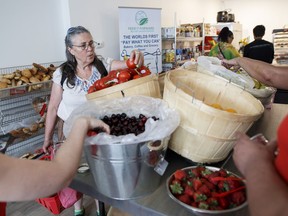 People are seen shopping for produce at Feed it Forward's Pay-what-you-can grocery store in Toronto, Ontario on Saturday, June 16, 2018.