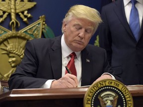 President Donald Trump signs an executive order on extreme vetting during an event at the Pentagon in Washington on January 27, 2017. Not only were Canadian officials scrambling to limit problems for travellers, they were simply trying to grasp what was going on when the Trump administration issued an executive order last year banning people from seven predominantly Muslim countries from entering the United States.