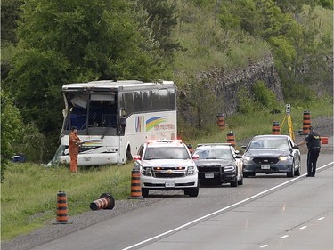 OPP officers work at the site of a crash involving a tour bus on Highway 401 West, near Prescott, Ont. on Monday, June 4, 2018.