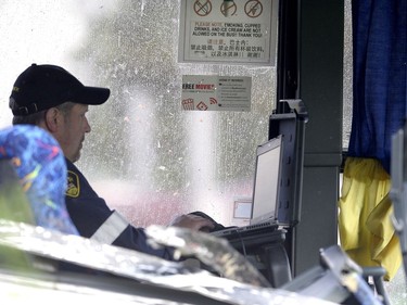 Signage in English and Chinese advising passengers to refrain from smoking and eating inside the bus is seen behind as an OPP officer working inside the tour bus that was involved in a crash on Highway 401 West, near Prescott, Ont. on Monday, June 4, 2018.