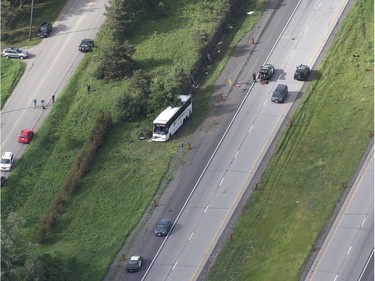 A bus sits on the side of highway 401 after crashing into a rock cut in Prescott, Ont., on Monday, June 4, 2018.