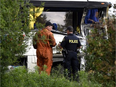 OPP officers work at the site of a crash involving a tour bus on Highway 401 West, near Prescott, Ont. on Monday, June 4, 2018. At least 24 people are in hospital, four with life-threatening injuries, after a bus crash in eastern Ontario, provincial police said Monday.