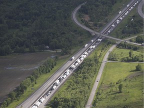 Traffic sits backed up in the westbound lanes of highway 401 after a bus crashed into a rock cut along the side of the highway in Prescott, Ont., on Monday, June 4, 2018.