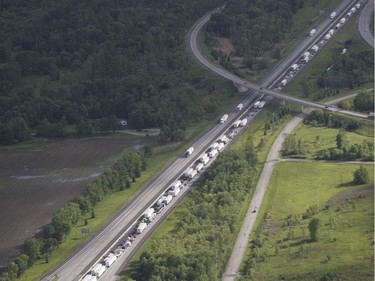 Traffic sits backed up in the westbound lanes of highway 401 after a bus crashed into a rock cut along the side of the highway in Prescott, Ont., on Monday, June 4, 2018.