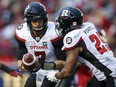 Ottawa Redblacks quarterback Trevor Harris, left, hands the ball off to William Powell during second half CFL football action against the Calgary Stampeders in Calgary, Thursday, June 28, 2018.