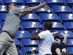 FILE - In this April 1, 2018, file photo, baseball fans attempt to catch a foul ball hit by Chicago Cubs' Kris Bryant during the seventh inning of a baseball game against the Miami Marlins, in Miami. A legend was made Tuesday, June 5, 2018, when a foul ball hit by Atlanta Braves'  Ender Inciarte landed in Gabby DiMarco's full cup of beer during the fifth inning of a baseball game against the San Diego Padres, in San Diego. DiMarco then stood up and chugged her entire drink.