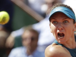 Romania's Simona Halep eyes the ball as she returns a shot against Spain's Garbine Muguruza during their semifinal match of the French Open tennis tournament at the Roland Garros stadium in Paris, France, Thursday, June 7, 2018.