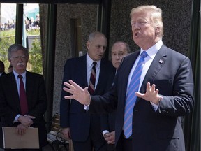 U.S. National Security Adviser John Bolton, left to right, White House Chief of Staff John Kelly, and Director of the United States National Economic Council Larry Kudlow look on as U.S. President Donald Trump speaks before departing from the G7 leaders summit in La Malbaie, Que., on Saturday, June 9, 2018.